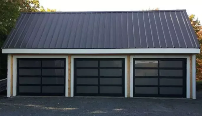 A garage featuring two full-view black doors.