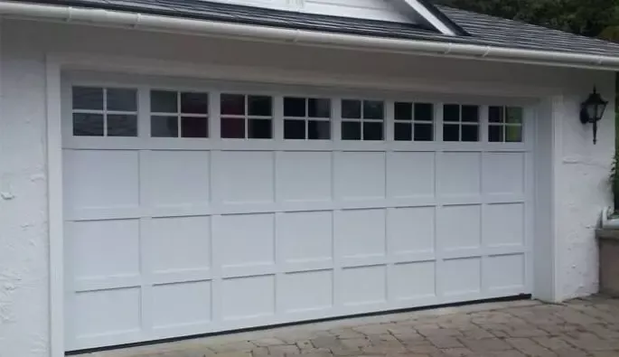 A white double garage door featuring white windows.