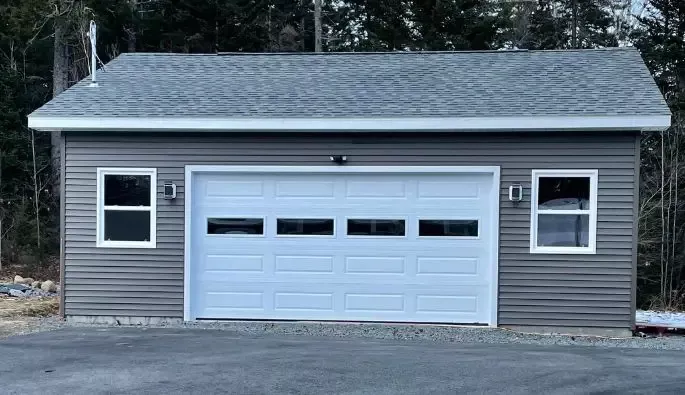 A garage featuring two windows and a garage door.